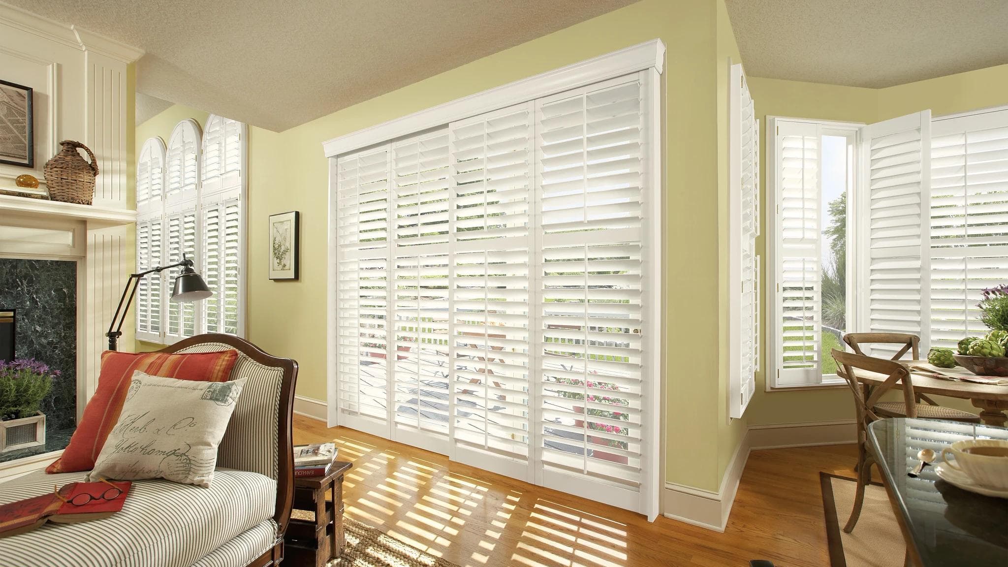 White shutters fitted to a living room window and adjacent bay